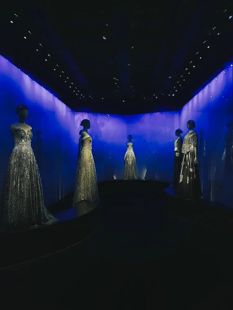 Abendkleider in blauem Licht einer Modeausstellung