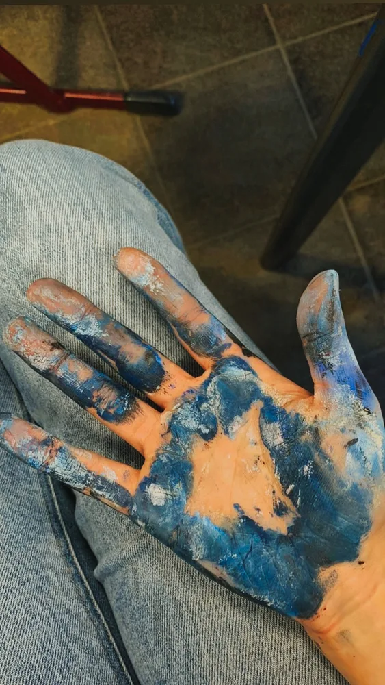 Handfläche voller blauer Farbe nach dem Malen