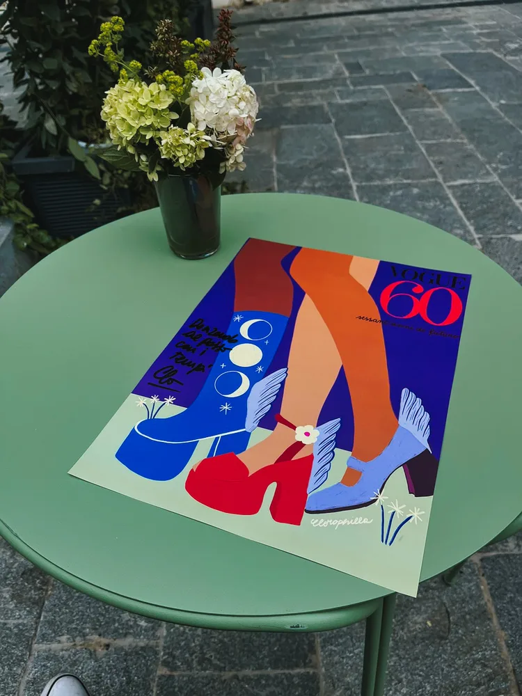 Illustriertes Vogue-Plakat auf einem grünen Cafétisch